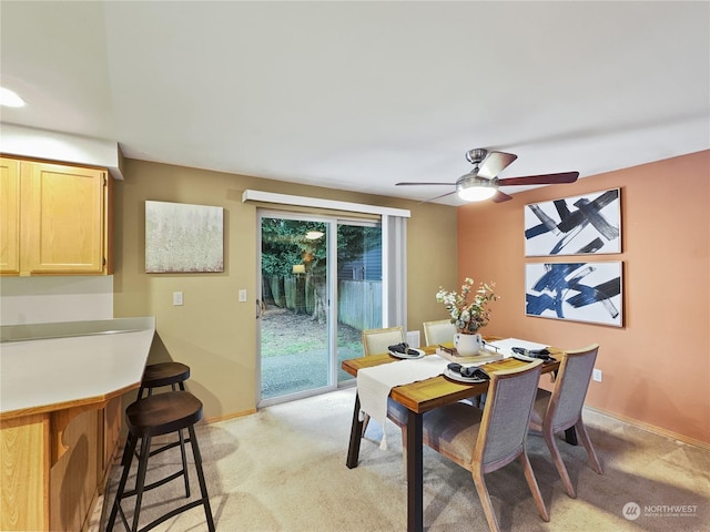 carpeted dining space with ceiling fan