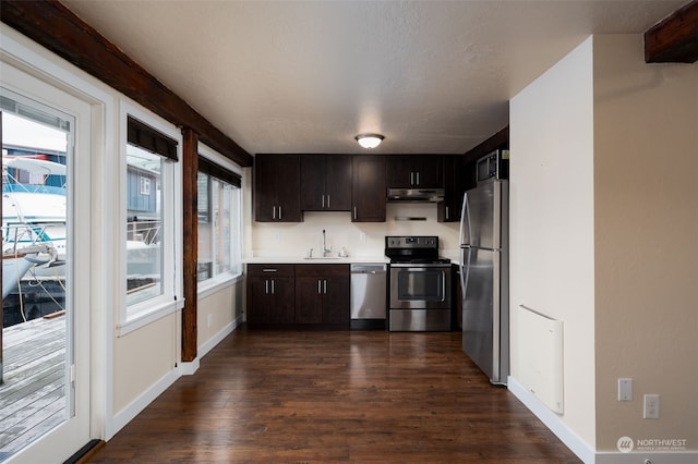 kitchen with appliances with stainless steel finishes, dark hardwood / wood-style flooring, sink, and dark brown cabinets