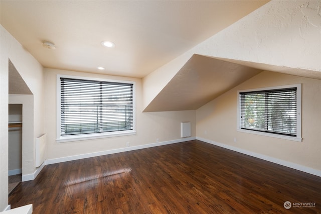 additional living space with lofted ceiling and dark hardwood / wood-style flooring