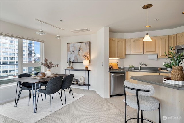 kitchen featuring pendant lighting, sink, ceiling fan, stainless steel dishwasher, and light brown cabinets