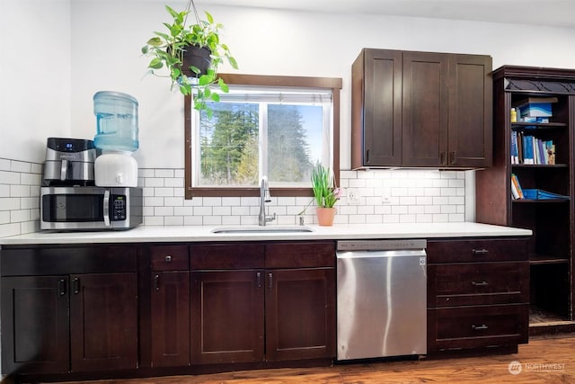 kitchen with dark brown cabinetry, sink, tasteful backsplash, appliances with stainless steel finishes, and light hardwood / wood-style floors