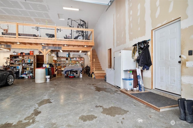 garage featuring a workshop area and white fridge