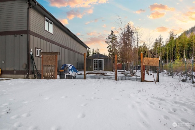 snowy yard featuring a storage shed