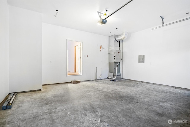 garage featuring a garage door opener, heating unit, and electric panel