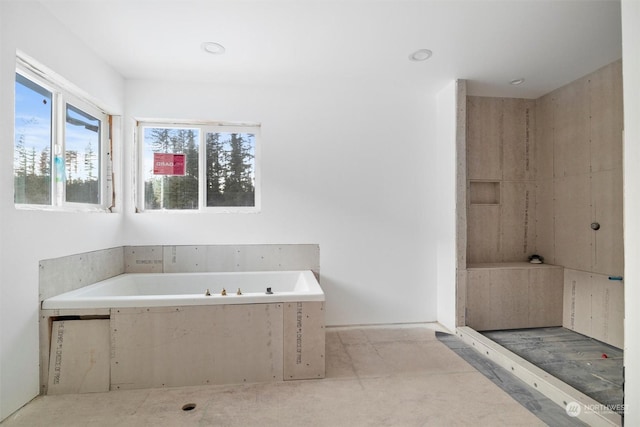 bathroom featuring a relaxing tiled tub