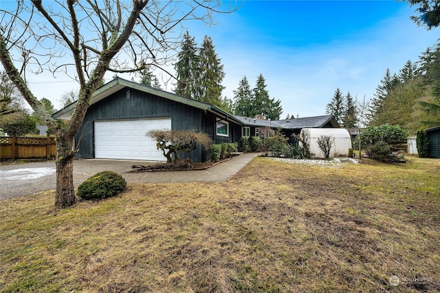 ranch-style house featuring a garage and a front lawn