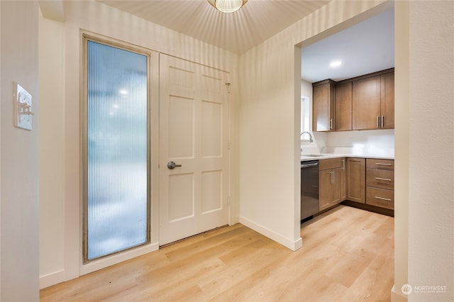 kitchen featuring sink, stainless steel dishwasher, and light hardwood / wood-style floors