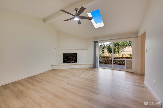 unfurnished living room with lofted ceiling with skylight, ceiling fan, and light wood-type flooring