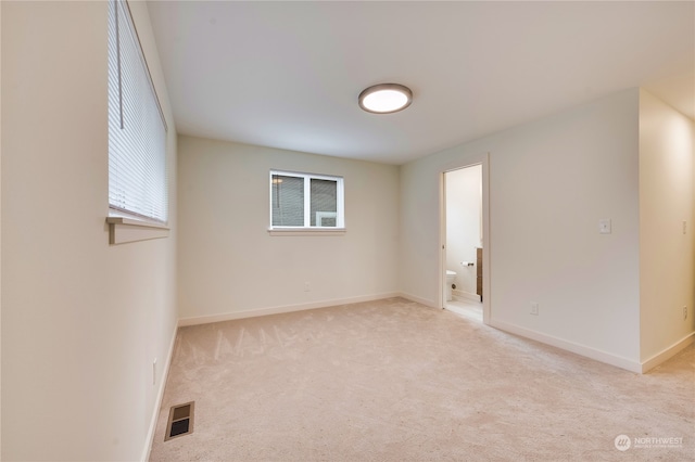 spare room featuring light colored carpet