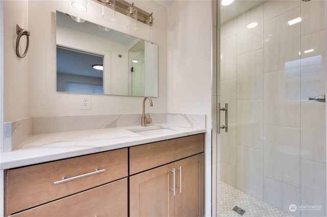 bathroom featuring vanity and a shower with door