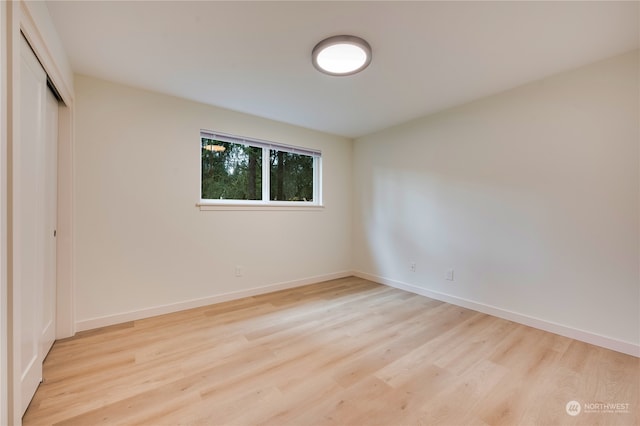 unfurnished bedroom featuring light hardwood / wood-style floors and a closet