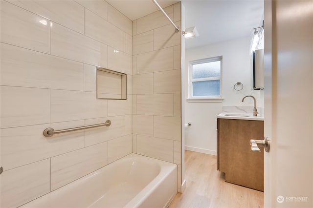 bathroom featuring vanity, tiled shower / bath combo, and hardwood / wood-style floors