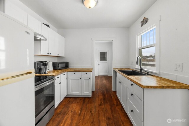 kitchen with stainless steel electric stove, wood counters, sink, white cabinets, and white fridge