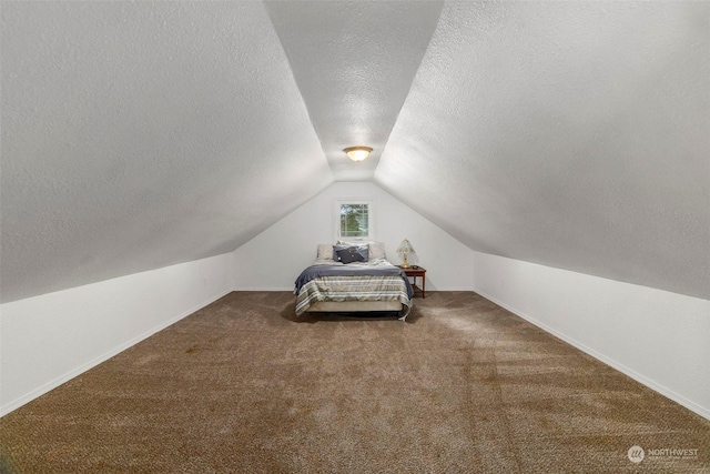 unfurnished bedroom featuring carpet floors, vaulted ceiling, and a textured ceiling