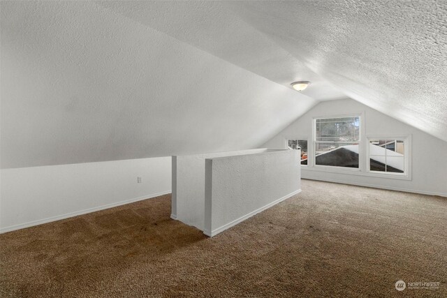 bonus room featuring lofted ceiling, a textured ceiling, and carpet flooring