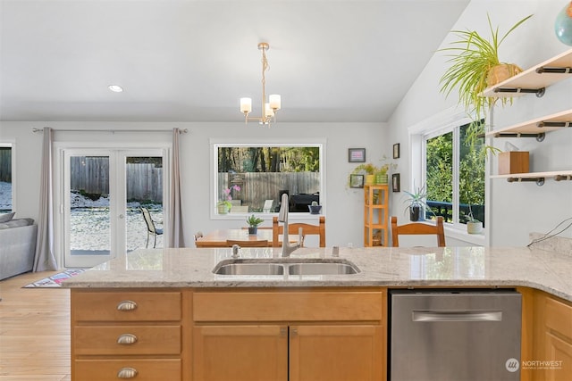 kitchen featuring lofted ceiling, sink, dishwasher, light stone counters, and light hardwood / wood-style floors