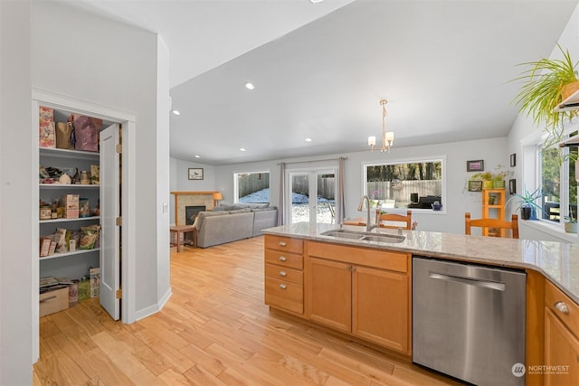 kitchen featuring sink, light hardwood / wood-style flooring, dishwasher, light stone countertops, and a chandelier