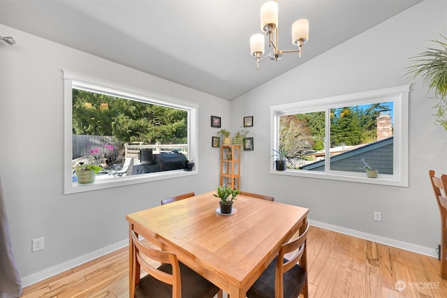 dining space with vaulted ceiling, a chandelier, and light hardwood / wood-style floors