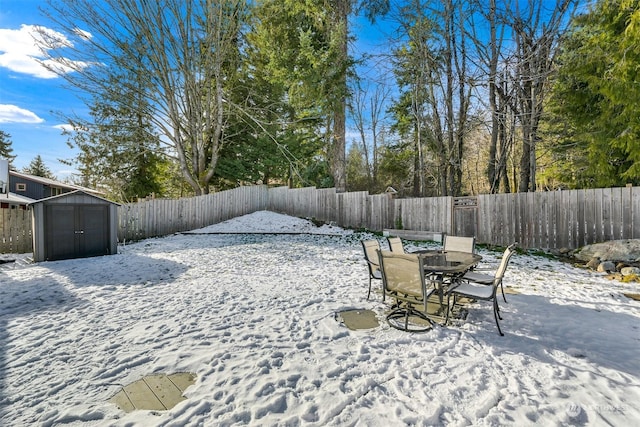 yard layered in snow featuring a storage unit