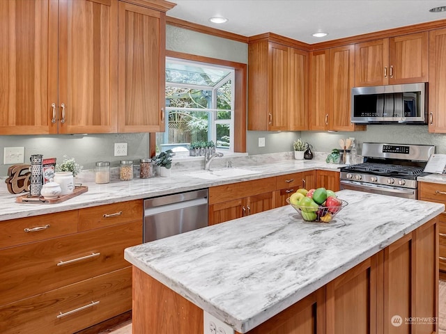 kitchen featuring light stone countertops, appliances with stainless steel finishes, sink, and a center island