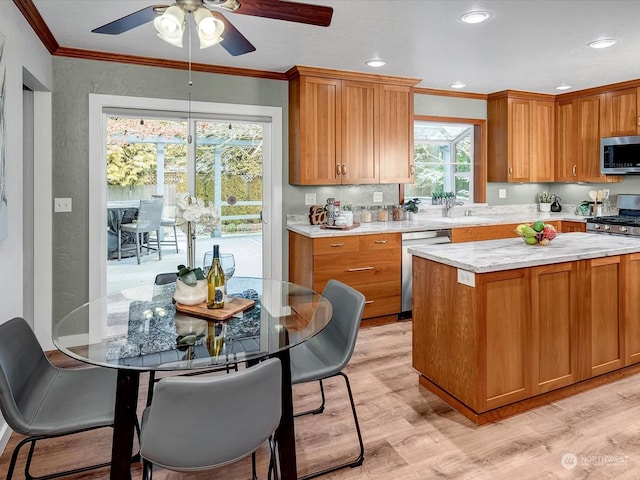 kitchen featuring light hardwood / wood-style flooring, sink, ornamental molding, and stainless steel appliances