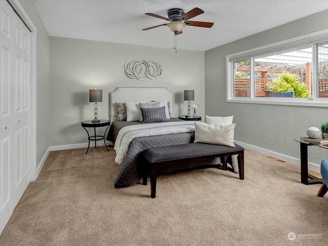 bedroom with light carpet, a closet, and ceiling fan