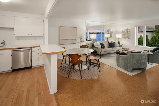 1600 43rd Ave E Unit 204, Seattle, WA 98112 - kitchen featuring sink, stainless steel dishwasher, white cabinets, and light hardwood / wood-style flooring