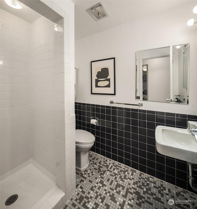 1600 43rd Ave E Unit 204, Seattle, WA 98112 - bathroom featuring sink, tile walls, tiled shower, tile patterned floors, and toilet