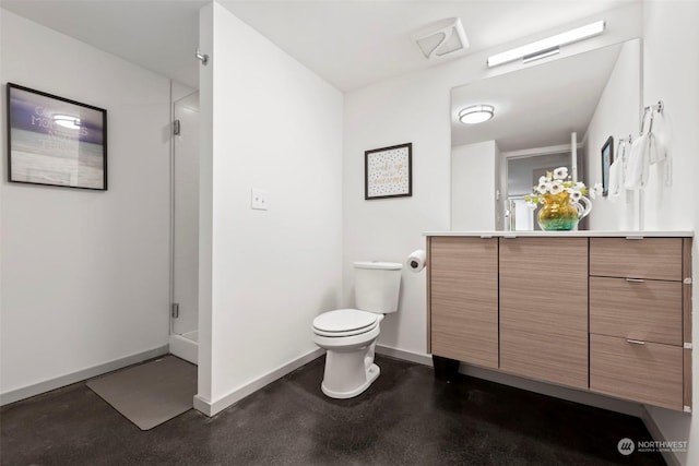 bathroom with vanity, a shower with shower door, and toilet