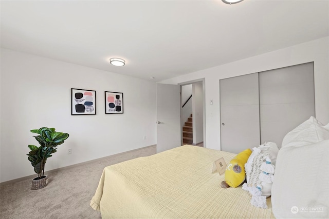 bedroom featuring light colored carpet and a closet