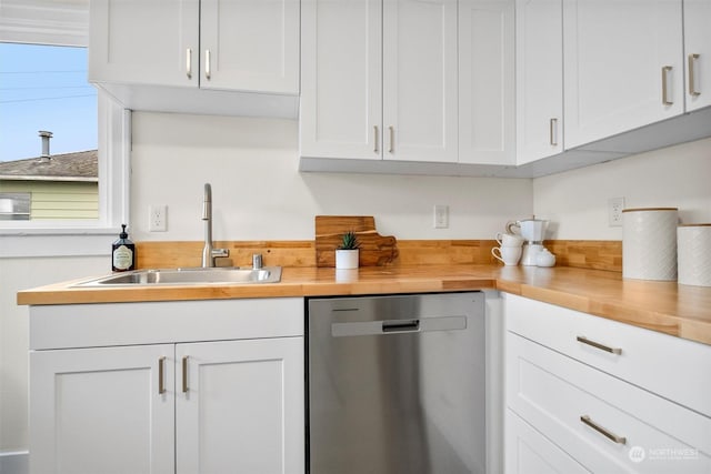 kitchen with white cabinetry, sink, stainless steel dishwasher, and wood counters