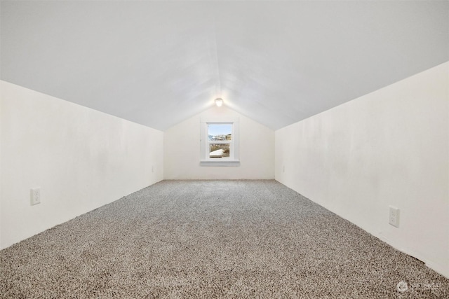 additional living space featuring lofted ceiling and carpet