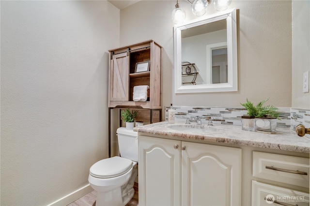 bathroom featuring tasteful backsplash, vanity, and toilet