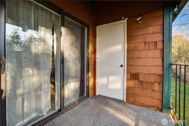 view of exterior entry featuring a balcony