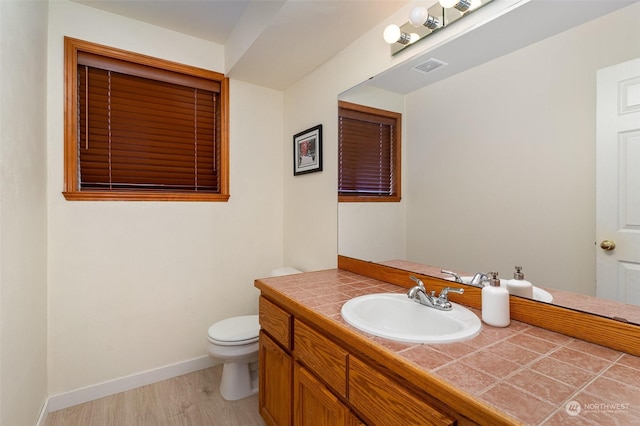 bathroom with vanity, wood-type flooring, and toilet