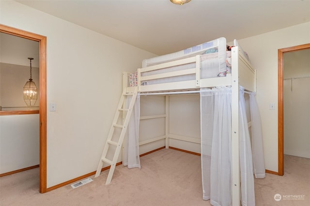 unfurnished bedroom with light carpet and a chandelier