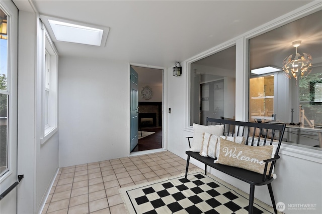 sunroom with a chandelier and a skylight