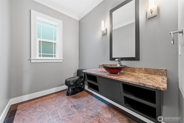 bathroom featuring ornamental molding, toilet, vanity, and baseboards