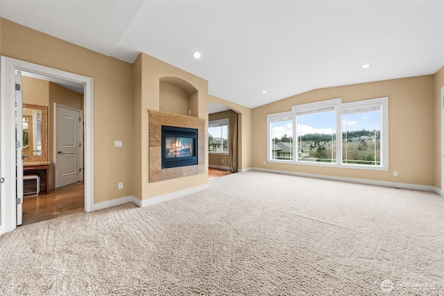 unfurnished living room with carpet, lofted ceiling, recessed lighting, baseboards, and a tiled fireplace