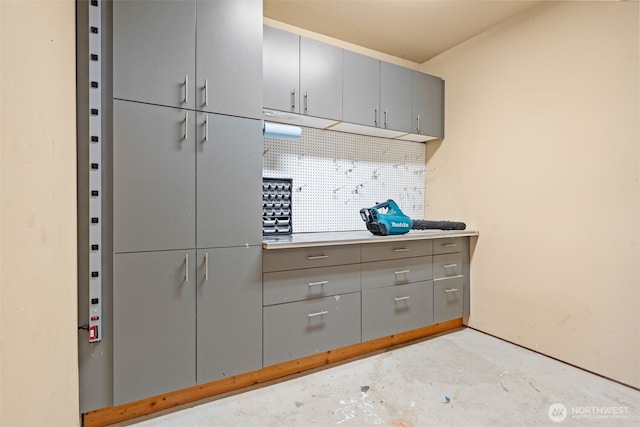 kitchen with gray cabinets and unfinished concrete floors