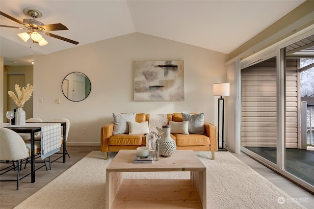 living room featuring ceiling fan, wood-type flooring, and vaulted ceiling