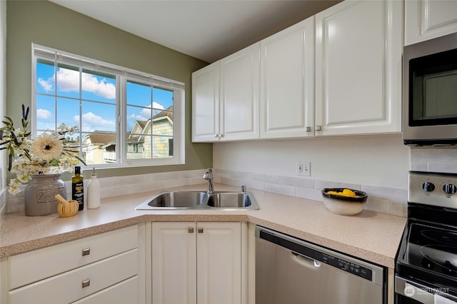 kitchen featuring stainless steel appliances, sink, and white cabinets