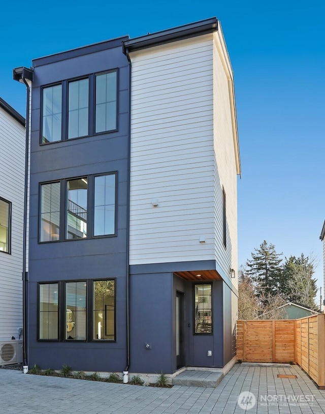 back of house with ac unit, stucco siding, and fence