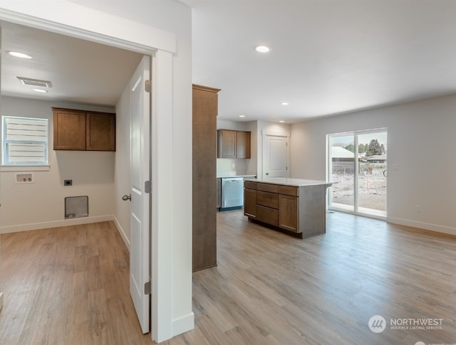 kitchen featuring dishwasher, a center island, and light wood-type flooring