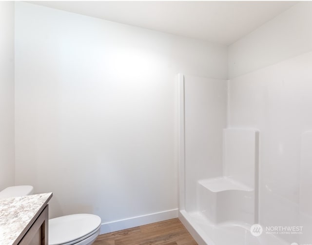 bathroom featuring vanity, toilet, hardwood / wood-style floors, and a shower