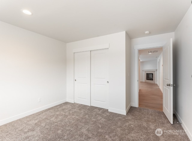 unfurnished bedroom with carpet floors and a closet