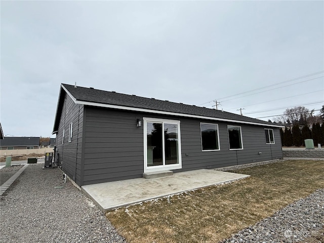 back of property with a lawn and a patio area