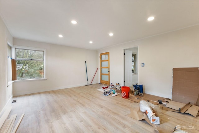 interior space with ornamental molding and light wood-type flooring