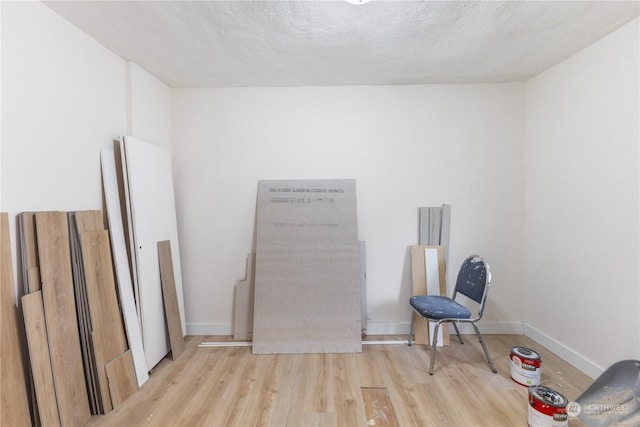 unfurnished room featuring light hardwood / wood-style floors and a textured ceiling