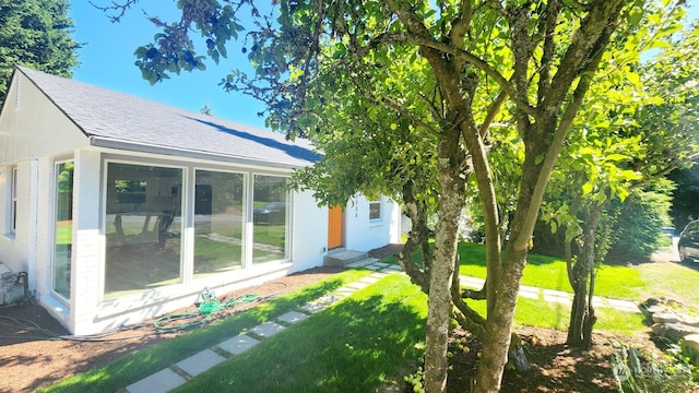 exterior space with a sunroom and a lawn